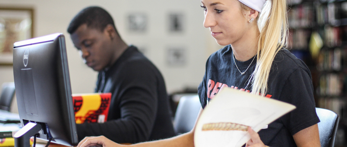 In addition to the award and recognition, LMC will receive a check for $4 thousand dollars that is tied to a new book fund for students in need, helping to ensure greater access to educational resources. Two students are studying with their books in front of computers.