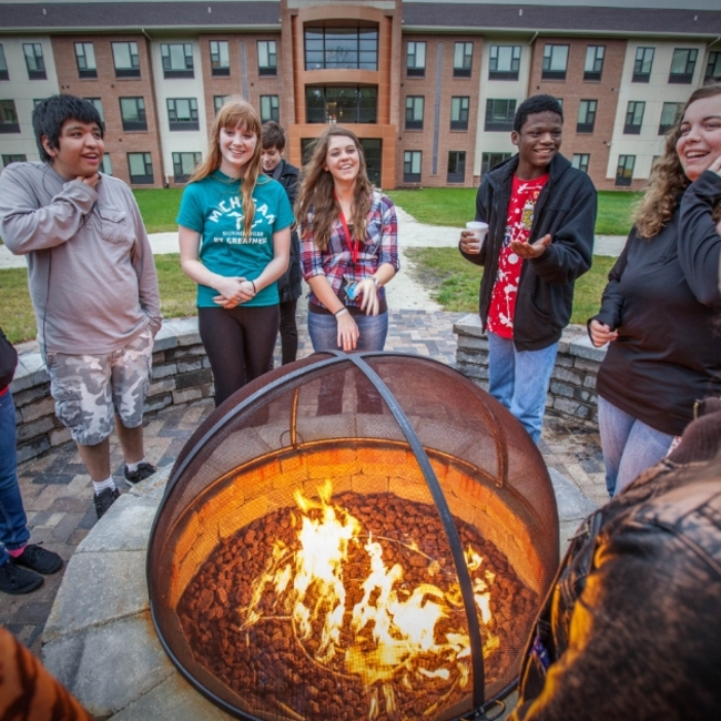 LMC students keeping warm by a fire pit.