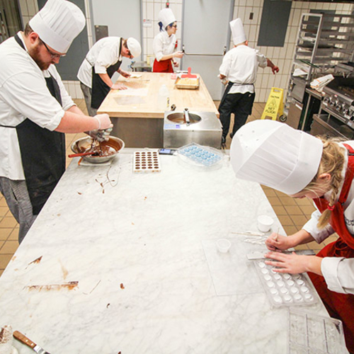 Students working with chocolate in the teaching kitchen.
